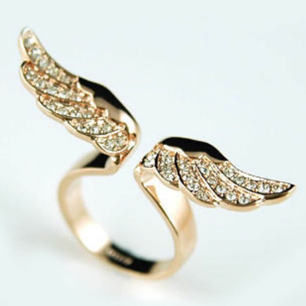 A stunning golden ring with intricately designed angel wings that wrap around the finger. The elegant and unique shape of this ring is perfect for anyone looking for a statement piece of jewelry. With its warm golden tones and detailed craftsmanship, this ring is a beautiful addition to any collection.